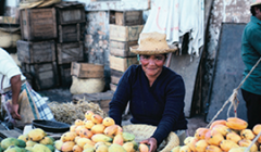 A vendor sells fruits on the street.
